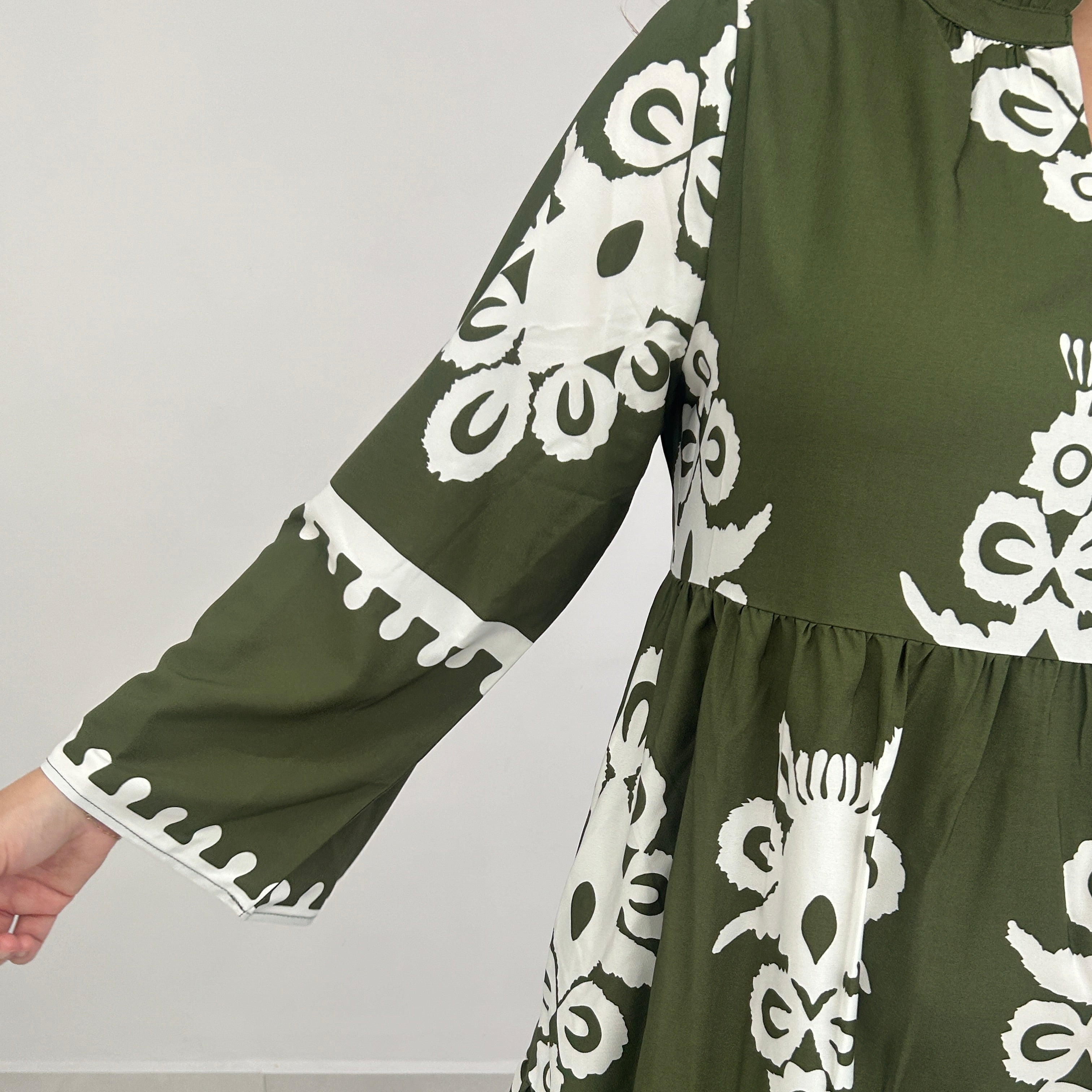 Green fabric with white floral patterns on a light gray background