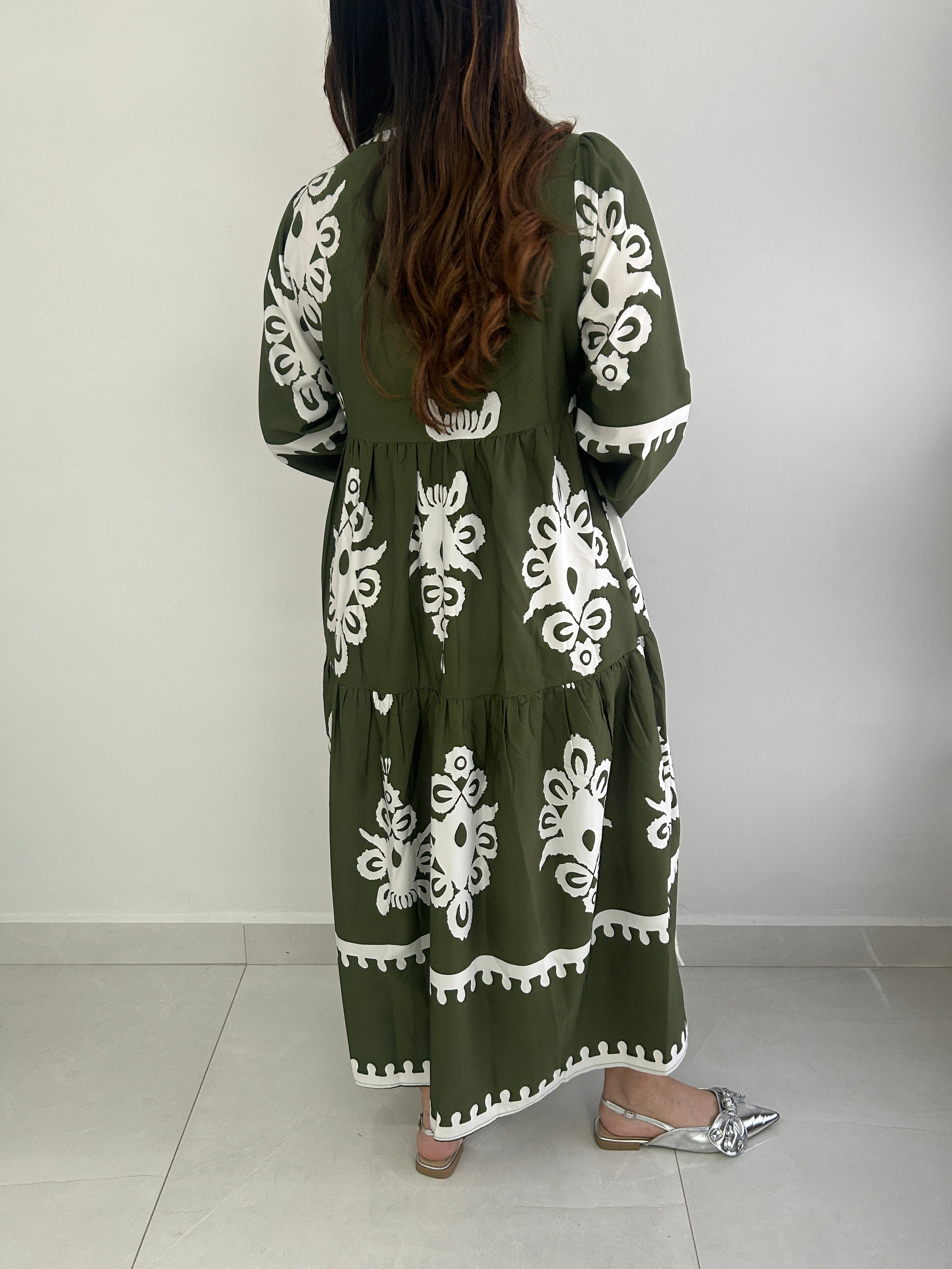 Person wearing a green dress with white floral patterns.