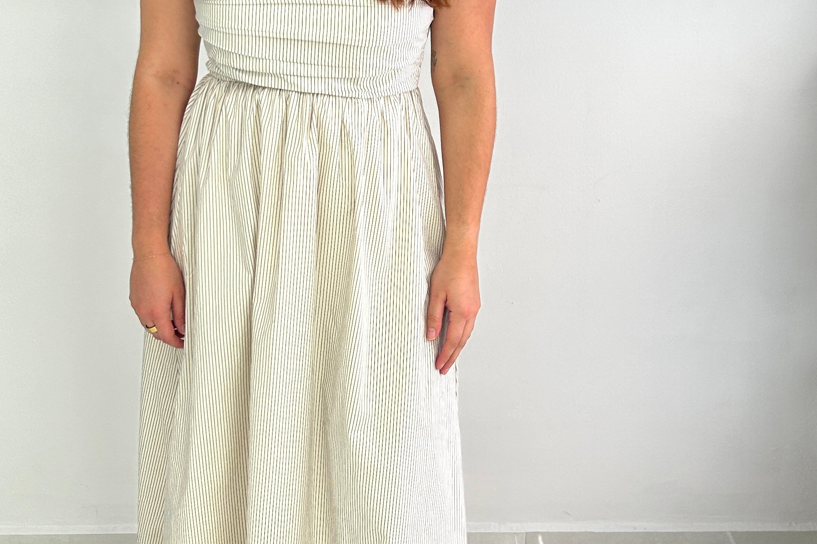 Woman wearing a white strapless dress against a white background