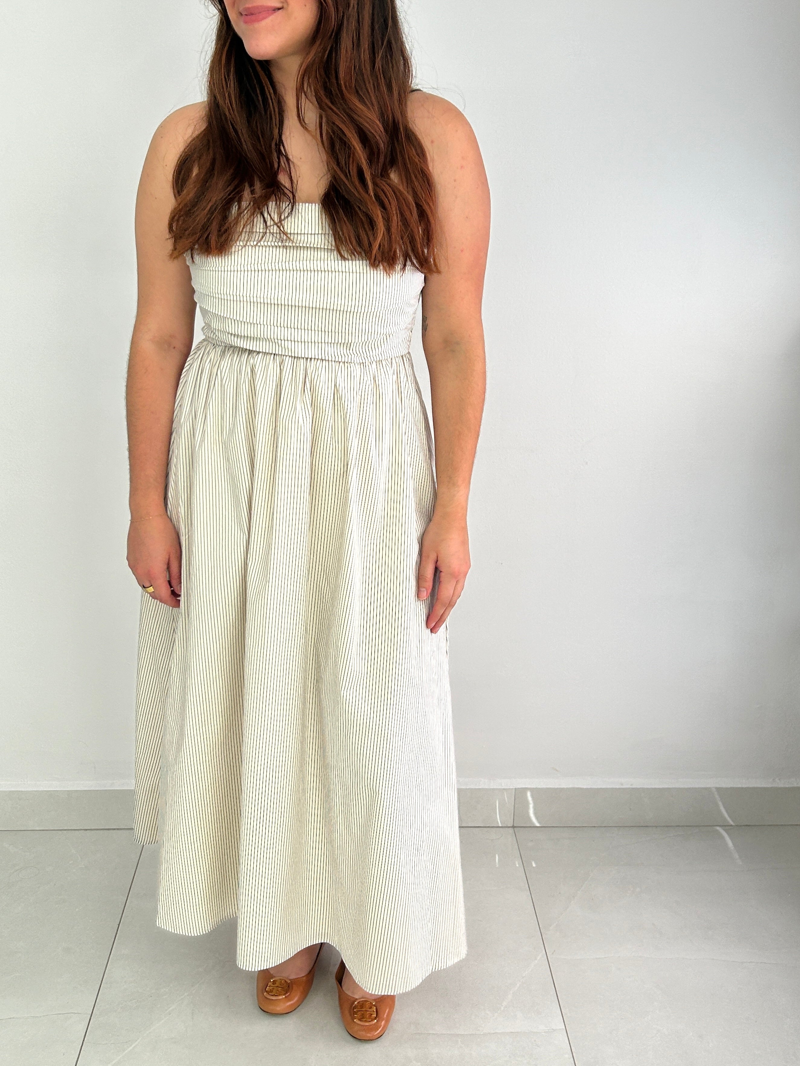 Woman wearing a white strapless dress against a white background