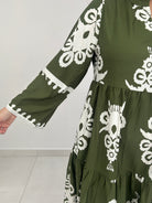Green fabric with white floral patterns on a light gray background