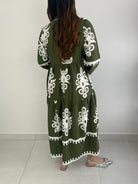 Person wearing a green dress with white floral patterns.